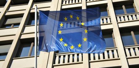 Die EU-Flagge weht vor einem Bürogebäude.