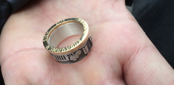 Ein Ring (Ehrung durch den Bielefelder Frauenpreis), der auf einer Handinnenfläche liegt.