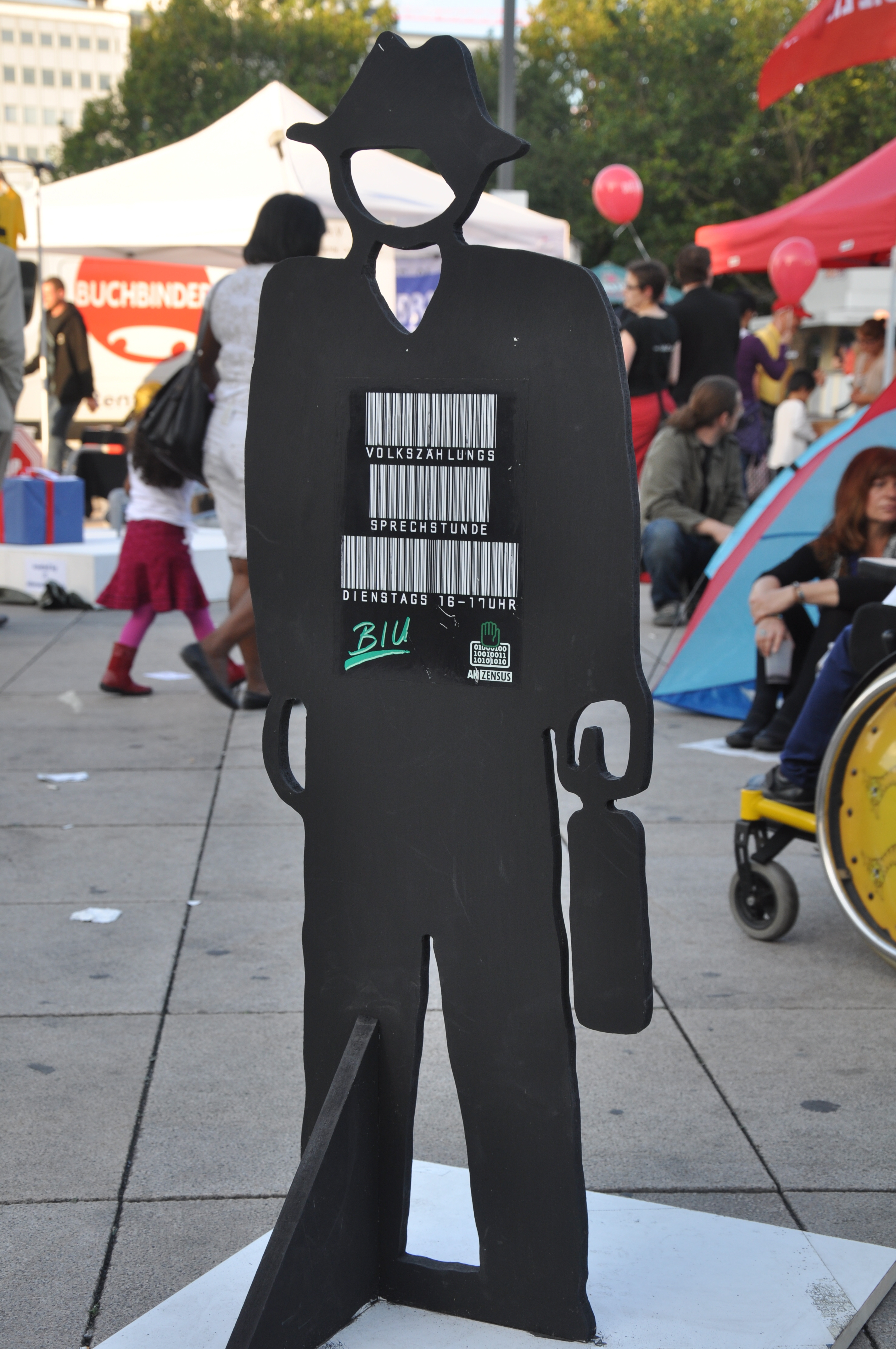A cardboard stand in the shape of a man with barcodes printed on it
