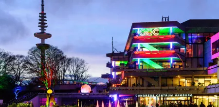 Das Congress Centrum Hamburg bei Dämmerung bunt beleuchtet.
