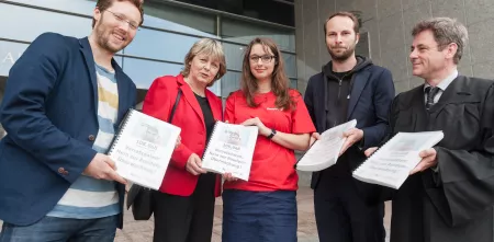 Mehrere Personen mit gesammelten Unterschriften als Ringbuch.