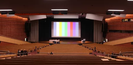Ein großer Veranstaltungssaal. Auf der Leinwand ein Testbild.