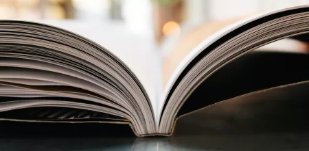 Ein aufgeschlagenes Buch, bei welchem man dein einzelnen Seiten von der Seite sieht.