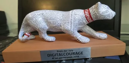 Der taz-panterpreis 2014 in Form eines Panters, der in Zeitungspapier gekleidet ist.