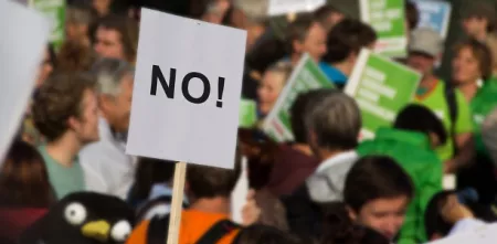 Menschen auf einer Demonstration. Ein Schild, auf dem „No“ steht.