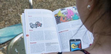 Ein Over-The-Shouolder-Foto, das eine Person zeigt, die im Buch „Kids, Digital, Genial“ liest.