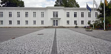 Das Bundeskartellamt von außen (weißes, zweistöckiges Gebäude).