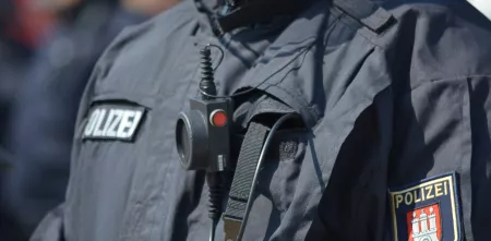 Detailaufnahme des Brustbereichs eines.einer Polizist.in, im Fokus die Aufnäher der Polzei.