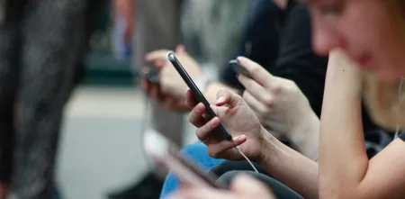 Detailaufnahme eines Smartphones, welches in einer Hand gehalten wird.