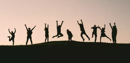 Silhouette von mehrere Menschen, die in die Luft springen.