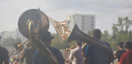 Ein Blasorchester von von hhinten fotografiert, im Hintergrund eine Menschenmenge.