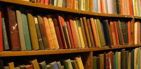 Ein Regal mit alten, bunten Büchern (Nahaufnahme).