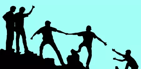 Silhouette von Menschen, die sich gegenseitig helfen, einen Hügel zu erklimmen