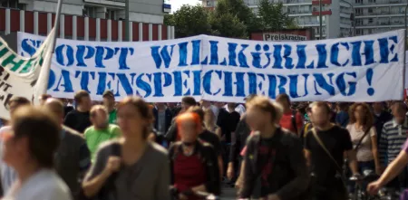 Demonstrant.innen mit einem riesigen Banner „Stoppt willkürliche Datenspeicherung“.