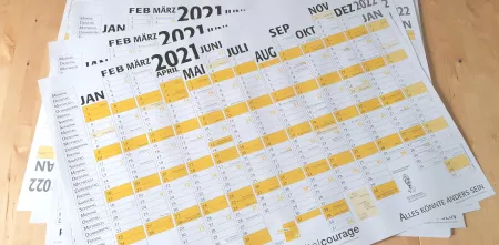 Die Kalender für das Jahr 2021 aufgefächert auf einem Tisch