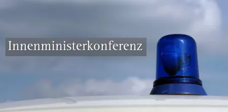 Ein Blaulicht. Links daneben der Text „Innenministerkonferenz“.