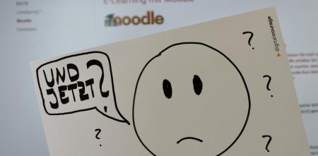 Zeichnung auf einer Postkarte: Ein traurig guckendes Emoji mit einer Sprechblase: „Und jetzt?“