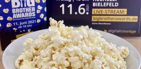 Eine Schüssel voll mit Popcorn. im Hintergrund ein BBA-Plakat.