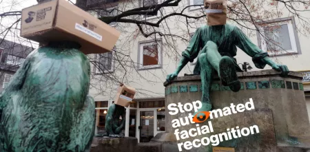 Diverse Statuen mit Papiertüten auf dem Kopf.