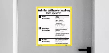 Eine Tür mit einem Schild mit Instruktionen, wie man sich im Fall einer Hausdurchsuchung verhalten sollte.