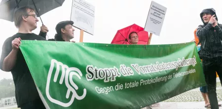 Mehrere Personen halten bei einem Protest ein Banner des AK Vorrat hoch. Darauf steht "Stoppt die Vorratsdatenspeicherung! - Gegen die totale Protokollierung der Telekommunikation."
