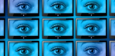 Eine Wand voller Smart-TVs. Jeder Bildschirm zeigt ein großes, offenes Auge.