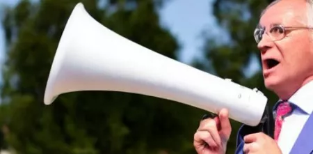 Ein Mann im Freien mit einem Megaphon in der Hand