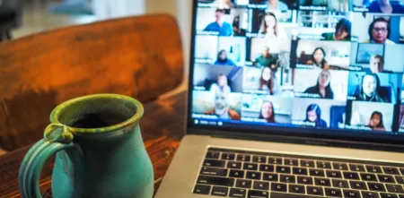 Foto eines Laptops mit vielen Personen, die an einer Videokonferenz teilnehmen.