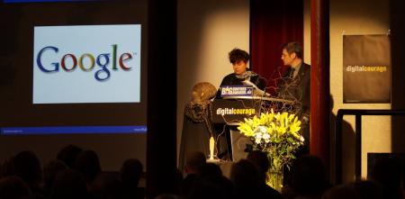 Rena Tangens und padeluun am Pult während der BBA-Verleihung 2013. Im Hintergrund ist das Google-Logo auf eine Wand projeziert.