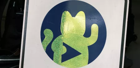 Eine Winkekatze auf einem Schild.