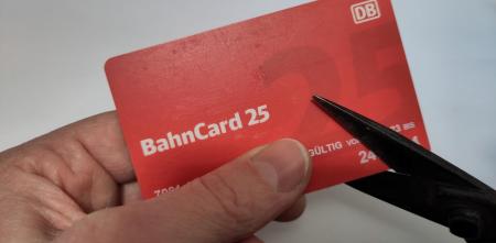 Eine Bahncard 25 wird mit einer Schere zerschnitten.