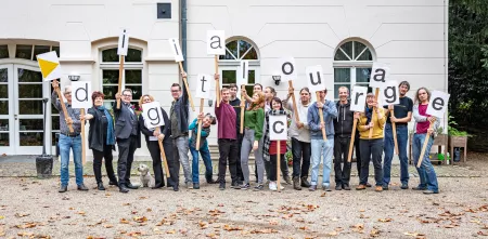 Das Team mit einzelnen Buchstabenschildern, die das Wort Digitalcourage bilden.