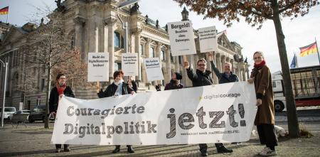 Menschen mit einem Banner „Couragierte Digitalpolitik jetzt!“ vor dem Deutschen Bundestag.