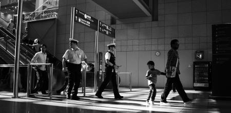 Polizisten an einer Bahnhofsrolltreppe, die sich umschauen.