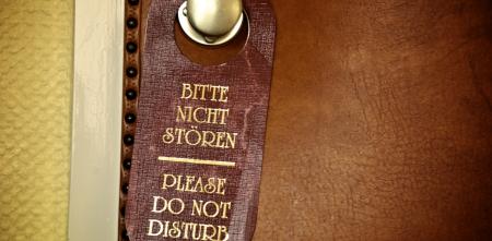 Detailaufnahme eines Türschildes mit dem Text „Bitte nicht stören“.