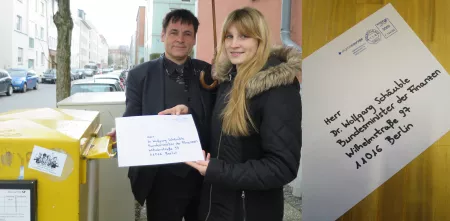 Zwei Teammitglieder von Digitalcourage werfen einen an Wolfgang Schäuble adressierten Brief in einen Briefkasten.