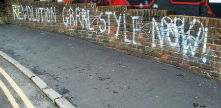 Eine Mauer besprüht mit: "Revolution Grrrl Style Now".