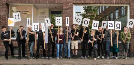 Das Team von Digitalcourage mit Schildern in der Hand, die das Wort Digitalcourage abbilden.