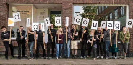 Das Team von Digitalcourage mit Schildern in der Hand, die das Wort Digitalcourage abbilden.