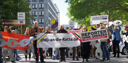 Aktivist.innen mit diversen Bannern auf einer Demo.