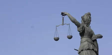 Eine Statue der Justitia mit einer Waagschale in der Hand.