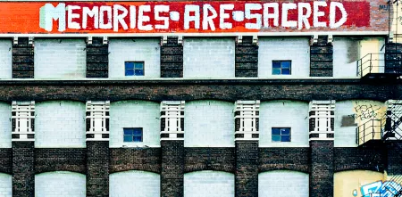 Riesige Häuserfassade. Ganz oben ein Graffiti: "Memories are sacred".