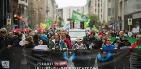 Demonstrant.innen mit einem riesigen „Rettet die Grundrechte“-Banner.