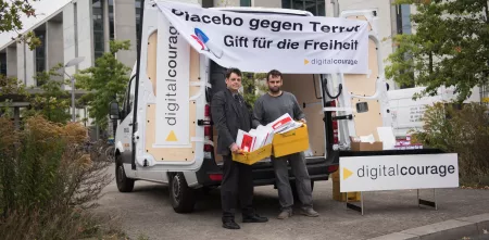 Aktionsstand von Digitalcourage mit einem Banner: „Placebo gegen Terror. Gift für die Freiheit.“