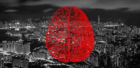 Collage: Im Hintergrund eine Großstadt bei Nacht (schwarz-weiß). Darüber eine Grafik eines Gehirns im Querschnitt (rot).