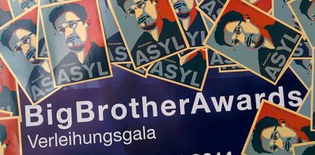 Ein BigBrotherAwards-Plakat zugeklebt mit ganz vielen Edward-Snowden-Asyl-Aufklebern.