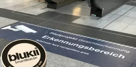 Auf dem Boden vor einer Rolltreppe ein riesiger Aufkleber: „Pilotprojekt Gesichtserkennung“