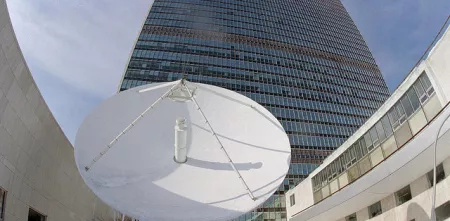 Eine riesige Satellitenschüssel vor einem Hochhaus.