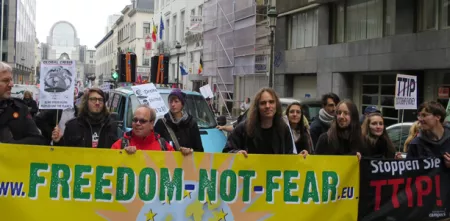 Demonstrant.innen mit einem Banner von "Freedom not Fear".