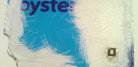 Eine sehr zerstörte Oystercard mit sichtbarem Chip.